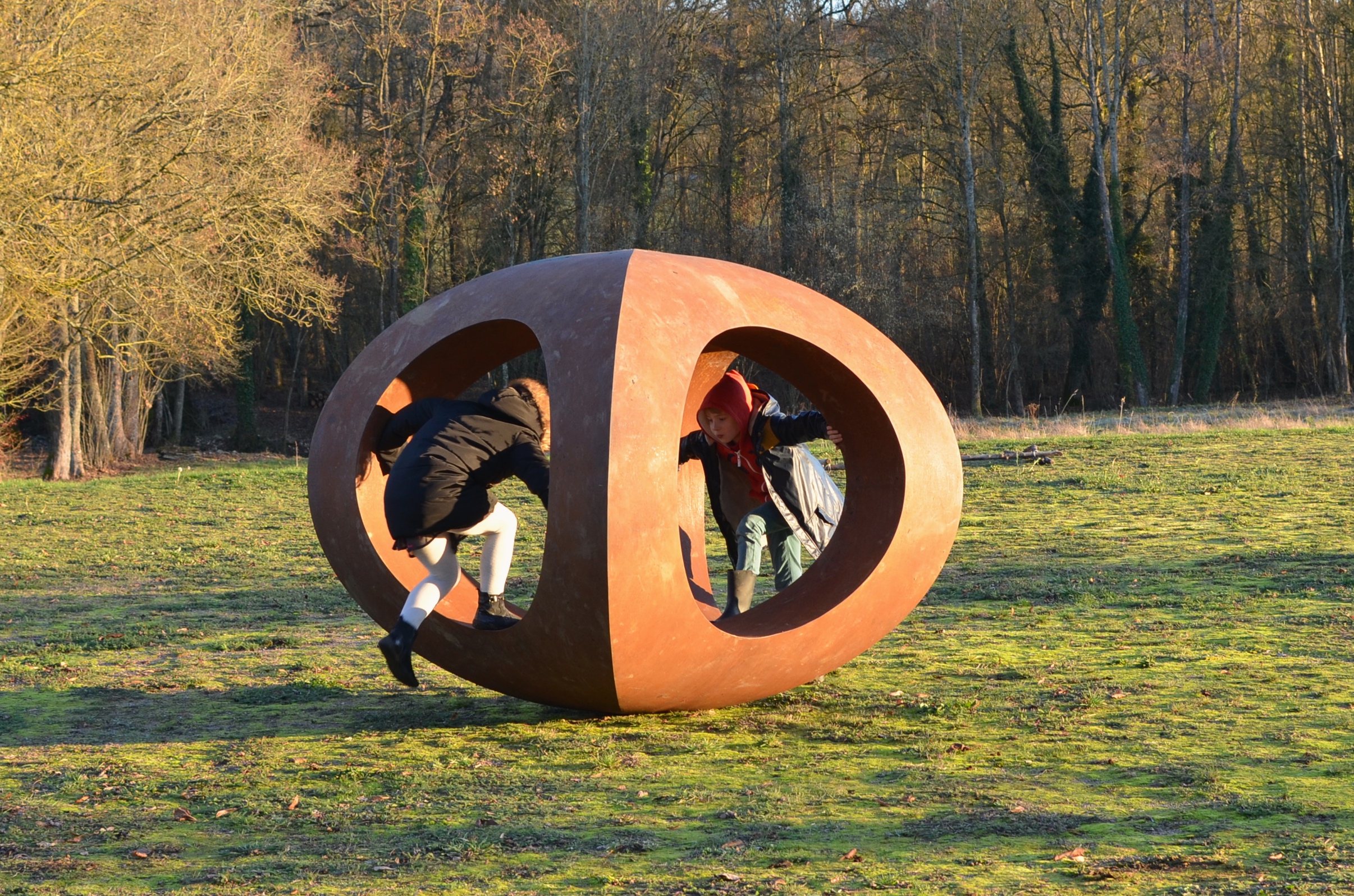 Deux enfants jouant dans une sculpture mathématiques au milieu d'un parc