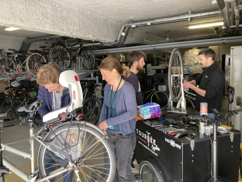 Plusieurs personnes réparent ensemble des vélos.
