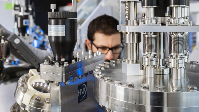 Technicien manipulant un cluster de croissance d'oxydes fonctionnels.