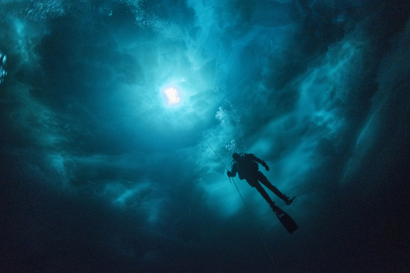 Scientific diver under a chaos of ice in the Young Sund fjord, Greenland
