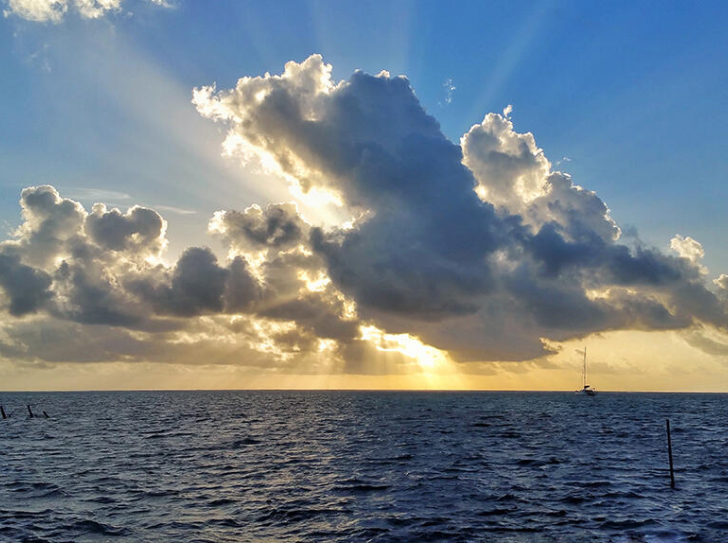Un lever de soleil à travers les nuages, au dessus de la mer