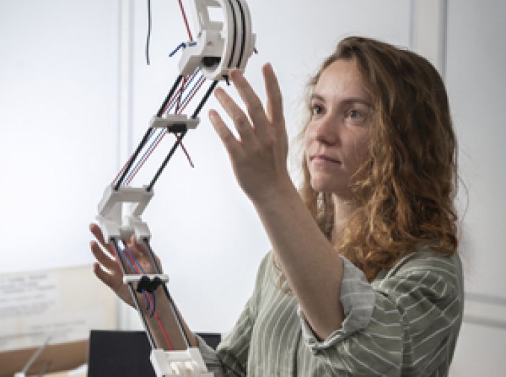 Une chercheuse manipule un bras articulé