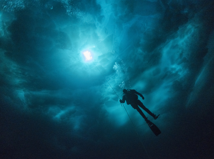 Scientific diver under a chaos of ice in the Young Sund fjord, Greenland