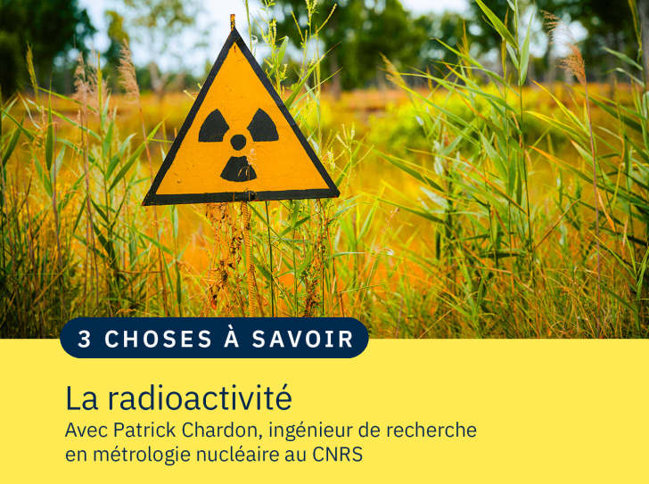 Un panneau avec le symbole de la radioactivité au milieu d'herbes hautes