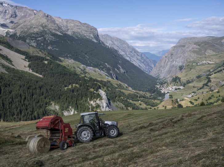 Tracteur rouge avec un paysage alpin en arrière-plan