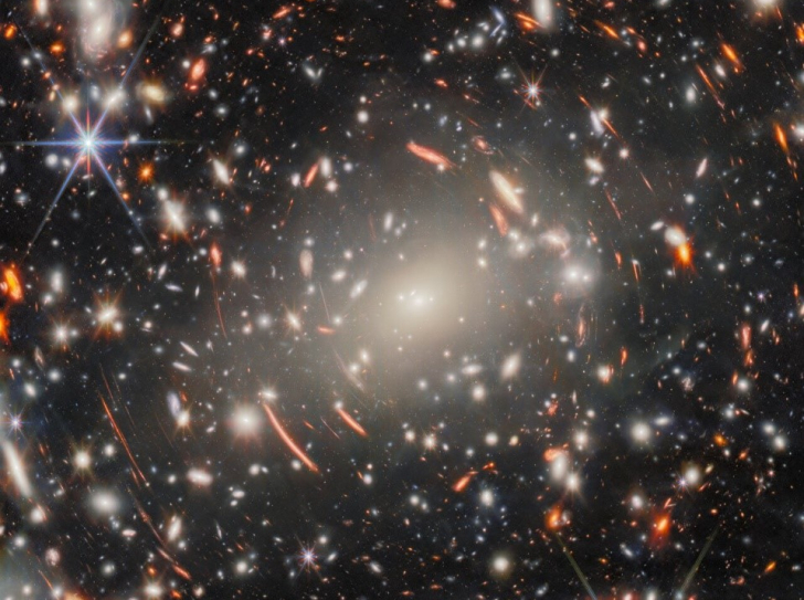 image du télescope James Webb, nombreuses étoiles et galaxies visibles, effet d'anneau de part et d'autre qui étire les images de certains objets