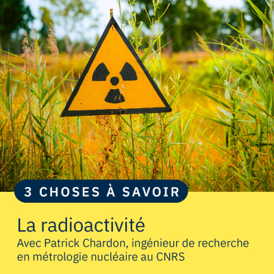 Un panneau avec le symbole de la radioactivité au milieu d'herbes hautes