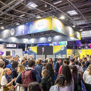 CNRS stand at VivaTech 2024 ; indoors during the day, a crowd of people are walking in front of the stand, we can see the ceiling with several metal structures and square windows