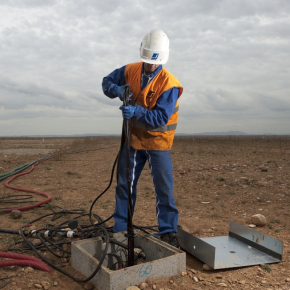 Un technicien sort une pompe d'un puits de captage d'eau, sur le site du chantier de réhabilitation