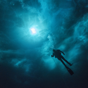 Scientific diver under a chaos of ice in the Young Sund fjord, Greenland