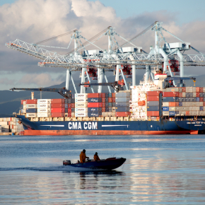 Une vedette passe devant un navire de l'armateur CMA-CGM dans le Grand Port Maritime de la Martinique.