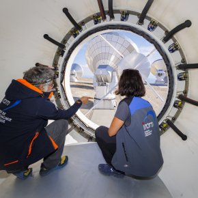 Discussion entre scientifiques au centre de la parabole d'une antenne de l'observatoire NOEMA