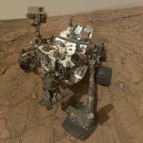 Vue en plongée du rover Curiosity de la NASA. Il se trouve sur le sol rouge - marron de la planète Mars.